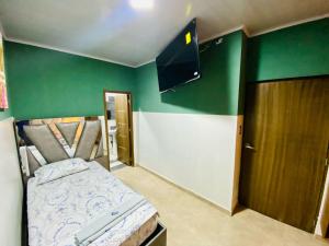 INKA HOTEL في كوكوتا: غرفة صغيرة بها سرير وتلفزيون بشاشة مسطحة