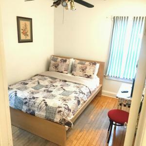 a bedroom with a bed and a red chair at Comfortable 3 BR Craftsman Bungalow in Milwaukee's Bay View Neighborhood in Milwaukee