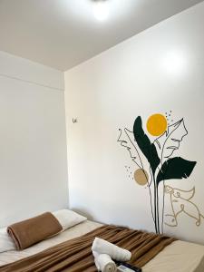 a bedroom with a bed with a flower on the wall at Pousada Marajó For You in Soure