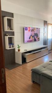 a living room with a flat screen tv on a wall at Ap completo melhor localização! Centro de Caxias. in Caxias do Sul