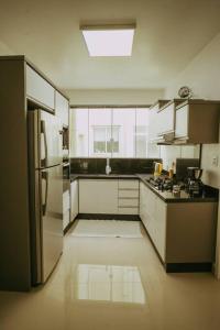 uma cozinha com armários brancos e um frigorífico em Ap completo melhor localização! Centro de Caxias. em Caxias do Sul