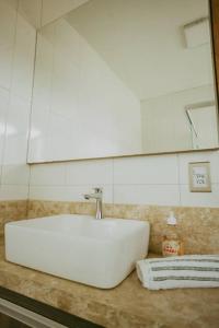 a white sink on a counter in a bathroom at Ap completo melhor localização! Centro de Caxias. in Caxias do Sul