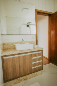 a bathroom with a sink and a mirror at Ap completo melhor localização! Centro de Caxias. in Caxias do Sul
