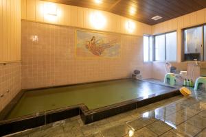 a bath room with a large pool of water at Ryokan TANAKAYA in Minobu