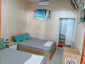 um pequeno quarto com 2 camas e um espelho em Khu du lịch Biển Cát em Ấp Long Sơn
