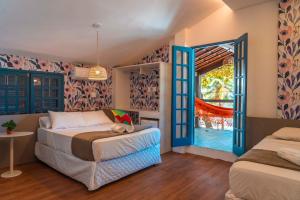 a bedroom with two beds and an open door at Apprezzare . Pousada beira-mar in Porto De Galinhas