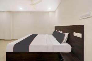 ein Schlafzimmer mit einem Bett mit einer schwarzen und weißen Decke in der Unterkunft Super Collection O Hotel Pnr International Mehdipatnam in Hyderabad
