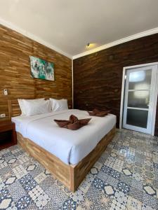 a bedroom with a large bed with a wooden wall at SUN RESORT GILI TRAWANGAN in Gili Trawangan