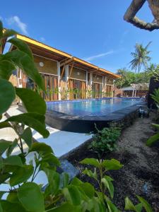 une maison avec une piscine en face de celle-ci dans l'établissement SUN RESORT GILI TRAWANGAN, à Gili Trawangan