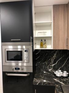 a kitchen with a microwave oven and a counter at Apartamento La Plana II in Castellón de la Plana