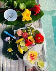 Pitaya Lodge by Lodge Paradise في سانت لوسي: طاولة مع طبق من الفواكه والخضروات على أوراق الشجر