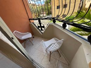 einen leeren Balkon mit zwei Stühlen und einem Fenster in der Unterkunft Cómodo y acogedor Amueblado in Santiago de los Caballeros