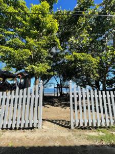 a white fence with trees and the ocean in the background at Casa de Diamantes in Tela
