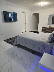 a bedroom with a bed and a tv on the wall at Skywin Airbnb - 1 Bedroom Apt&Sofa Bed - HWT, KGN in Camperdown
