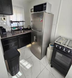 a kitchen with a stainless steel refrigerator and a stove at Skywin Airbnb - 1 Bedroom Apt&Sofa Bed - HWT, KGN in Camperdown