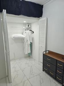 a room with a closet with white clothes and a dresser at Skywin Airbnb - 1 Bedroom Apt&Sofa Bed - HWT, KGN in Camperdown