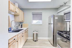 a kitchen with a stainless steel refrigerator and wooden cabinets at The Moose #6 - Modern Luxe Studio with Free Parking & King Bed in Memphis