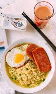 a bowl of ramen with eggs and toast and bread at Đăng Dương Motel in Sapa