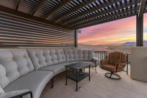 eine Couch auf einem Balkon mit Sonnenuntergang in der Unterkunft Paradise Private Pool Retreat #17 home in Santa Clara