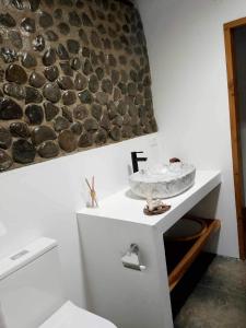 a bathroom with a white toilet and a sink at Vale Sekoula, Private Villa on the Ocean with Pool in Matei