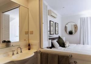 サファイア・ビーチにあるCasa Tropicana in Aqua Luna Resort - 1 BedRoom Ocean Views Surfs up!のバスルーム(鏡付きベッド1台、シンク付)