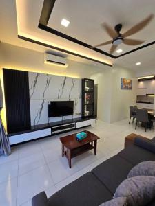 uma sala de estar com uma televisão, um sofá e uma mesa em Stay @ 71 Oasis Condominium Ipoh em Ipoh