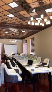 uma grande sala de conferências com uma mesa longa e cadeiras em CITY GARDEN HOTEL em Dushanbe
