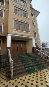 um edifício com uma escada em frente a um edifício em CITY GARDEN HOTEL em Dushanbe