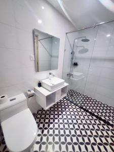 uma casa de banho com um WC, um lavatório e um chuveiro em Sunrise Hotel em Phu Quoc