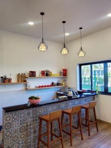 uma cozinha com um balcão com três bancos em Sunrise Hotel em Phu Quoc