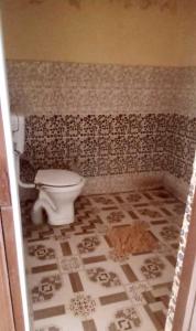 een badkamer met een toilet en een tegelvloer bij OYO S.R. Hotel in Meerut
