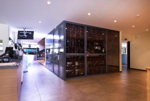 a wine cabinet with wine bottles in it at Hôtel Glanis in Gland