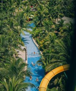 um parque de diversões com escorrega aquático e palmeiras em Sunrise Hotel em Phu Quoc