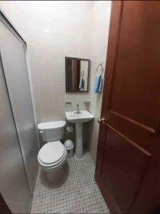 a bathroom with a toilet and a sink at VILLAS IXCHEL in Tapachula