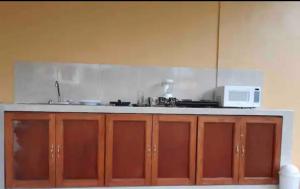a kitchen with brown cabinets and a white microwave at VILLAS IXCHEL in Tapachula