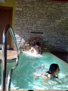 a man and a woman in a swimming pool at Alba D'Esteve. Casa Rural in Espot