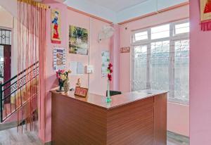 a pink room with a counter and a window at WONDER HILL GUEST HOUSE in Shillong