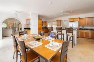 a dining room and kitchen with a wooden table and chairs at Royal Westmoreland - Ocean Drive 8 villa in Saint James