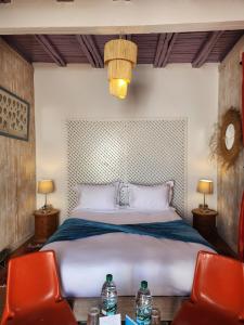 a bedroom with a large bed with two red chairs at Dar Adul in Essaouira