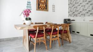 a kitchen with a wooden table and chairs at Calm Woods Villa Near Pandawa Beach in Nusa Dua