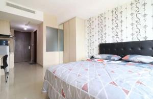 een slaapkamer met een groot bed met een zwart hoofdeinde bij Collection O 93707 Rooms By U in Tangerang