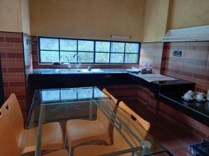 a kitchen with a glass table and a sink at Nature's Nest Kandy in Kandy