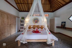 a bedroom with a bed with a mosquito net at Biorock Homestay & Dive Center Pemuteran in Pemuteran