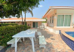 a white picnic table in front of a house at Home Hakim in Cha Am