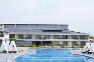 a hotel with a swimming pool in front of a building at Baywatch Resort, Colva Goa in Colva