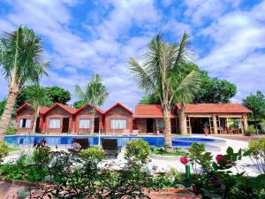 a resort with a swimming pool and palm trees at Tam Coc Green Garden Bungalow in Ninh Binh