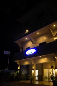 una gasolinera por la noche con un cartel de neón azul en ARNOLD'S HOTEL, en Pooc