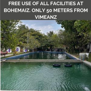 a pool of water in a park with text overlay free use of all facilities at at Vimeanz @Bohemiaz in Kampot