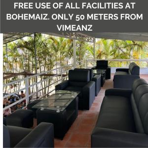 a waiting area at a hotel with chairs and tables at Vimeanz @Bohemiaz in Kampot