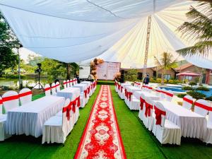 a set up for a wedding ceremony with white and red chairs at Tam Coc Green Garden Bungalow in Ninh Binh